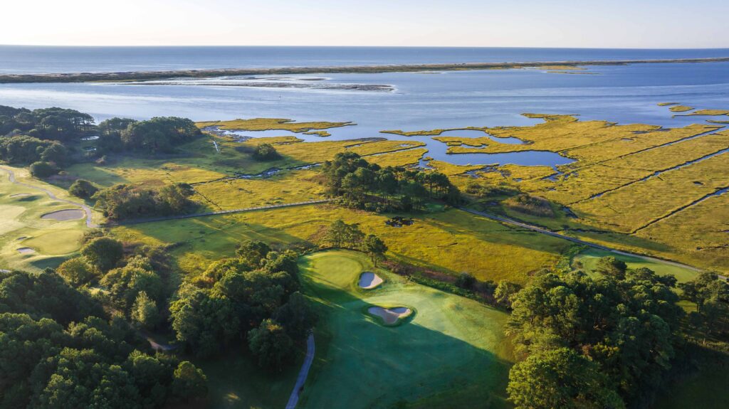 an aerial view of a golf course near a body of water