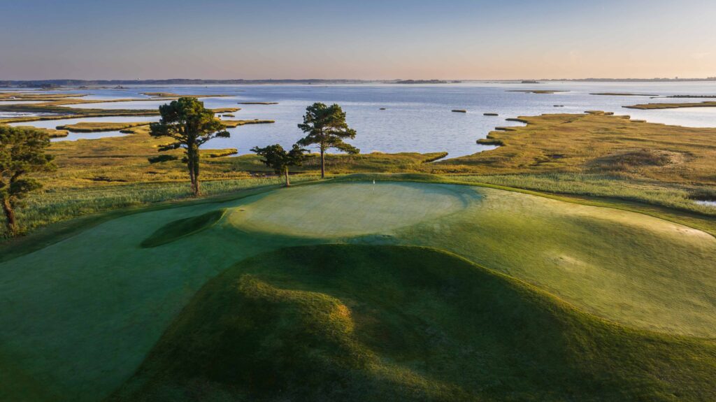 a golf course with a lake in the background