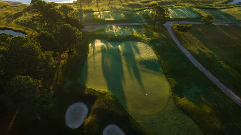 an aerial view of a golf course at sunset