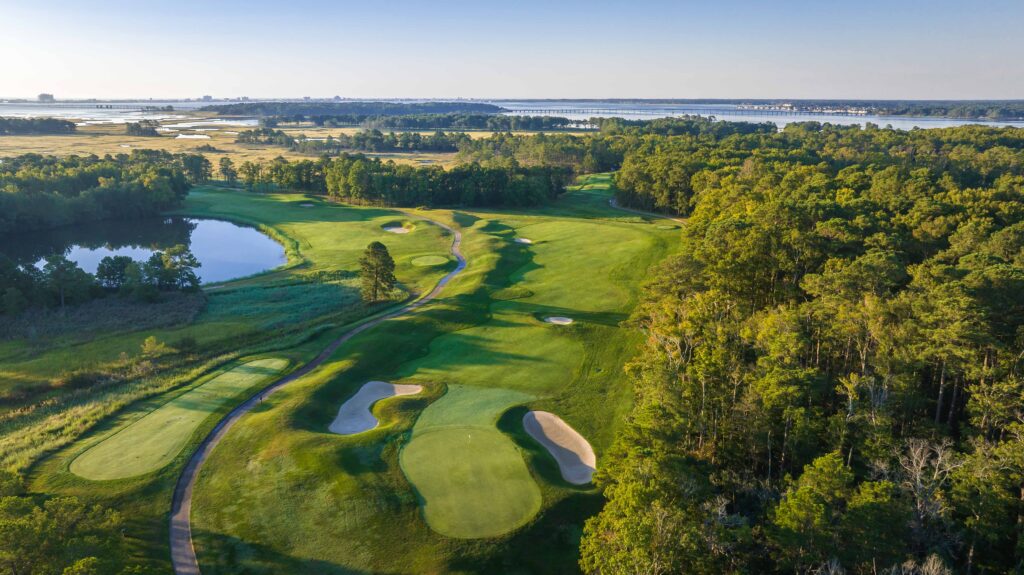 a golf course surrounded by trees and water