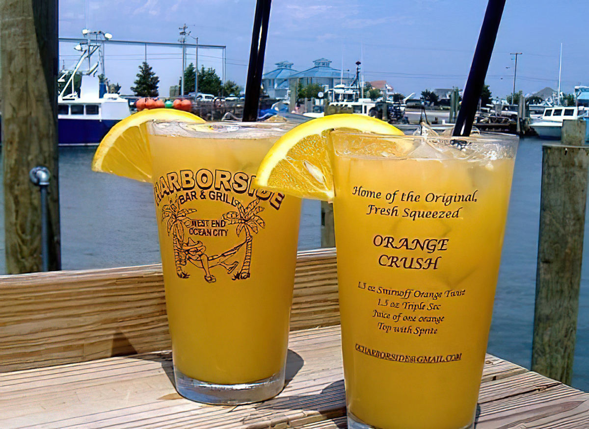 two glasses of orange juice sitting on a wooden table