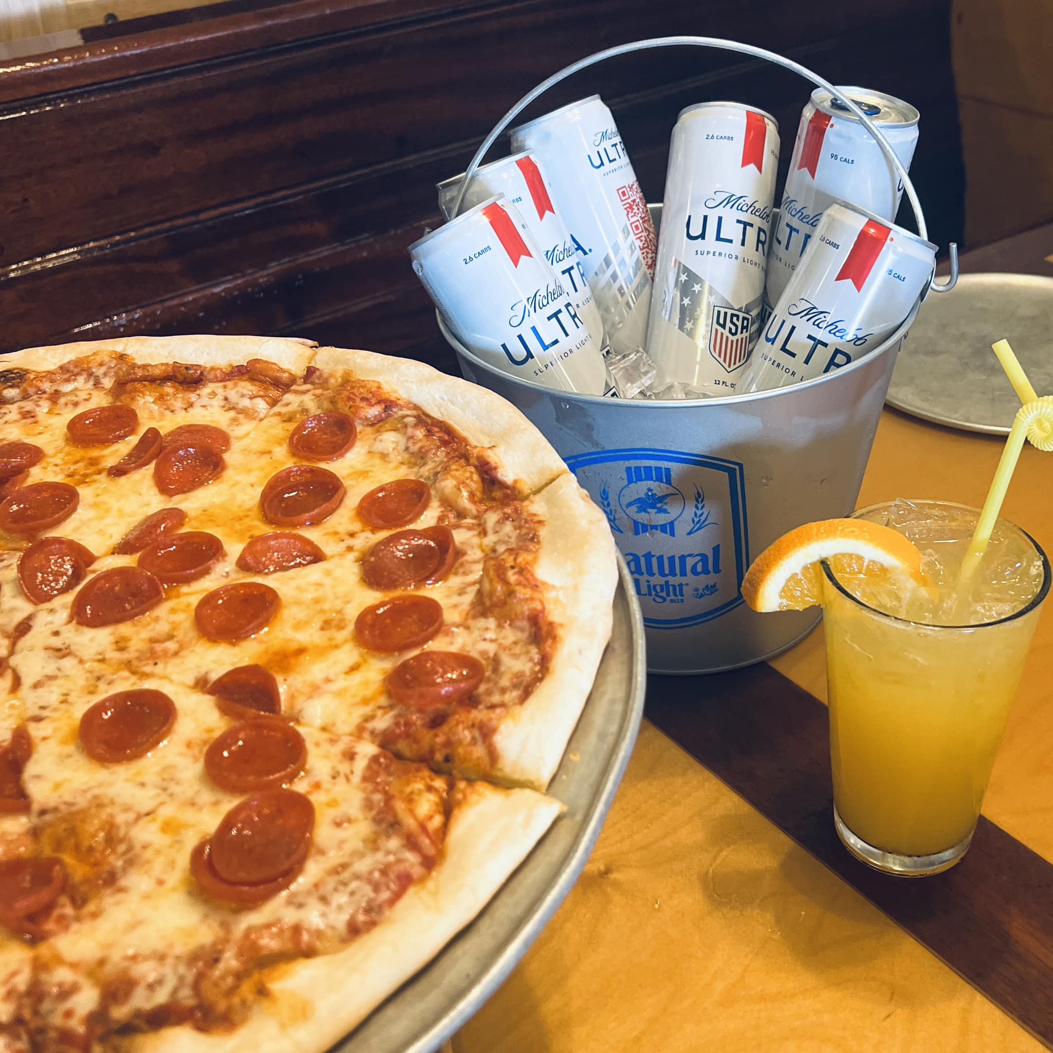 a large pepperoni pizza and a glass of orange juice