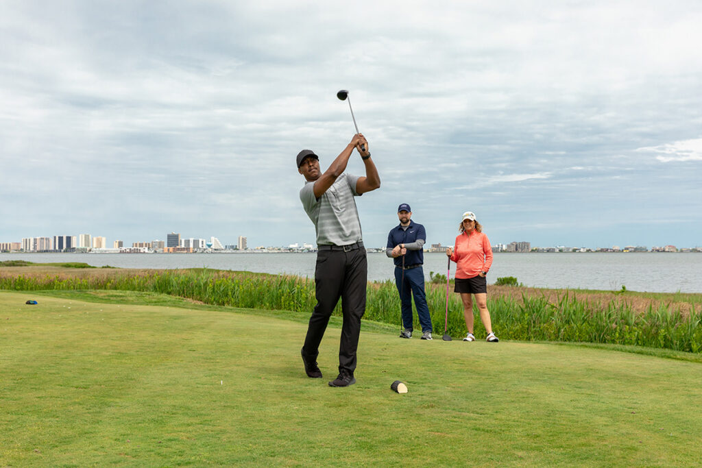 a man swinging a golf club on a golf course