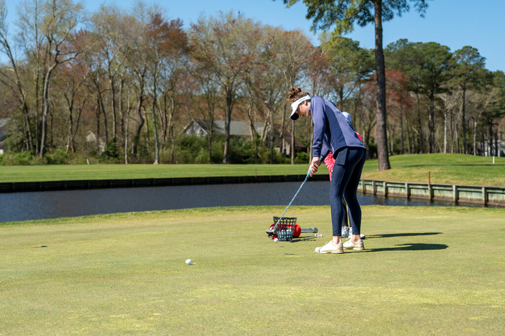 a woman putting a putt on a golf course