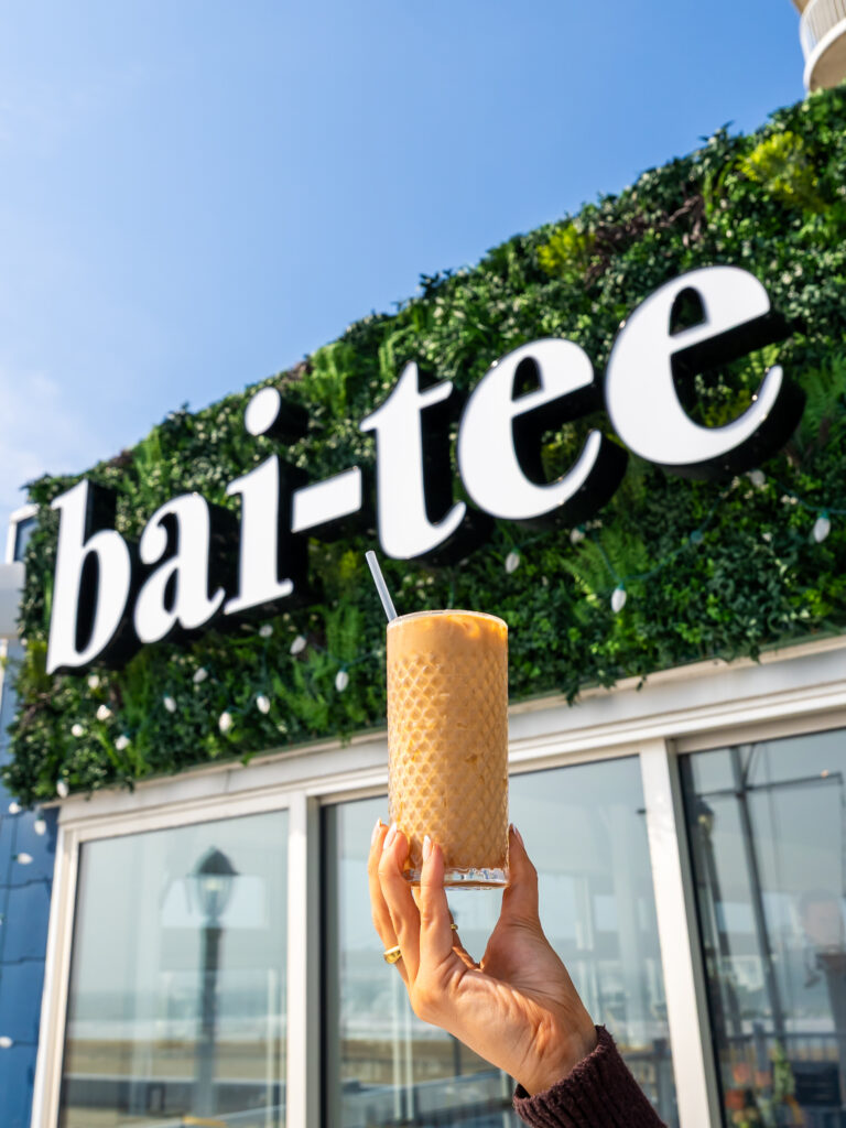 a person holding up an ice cream cone in front of a building