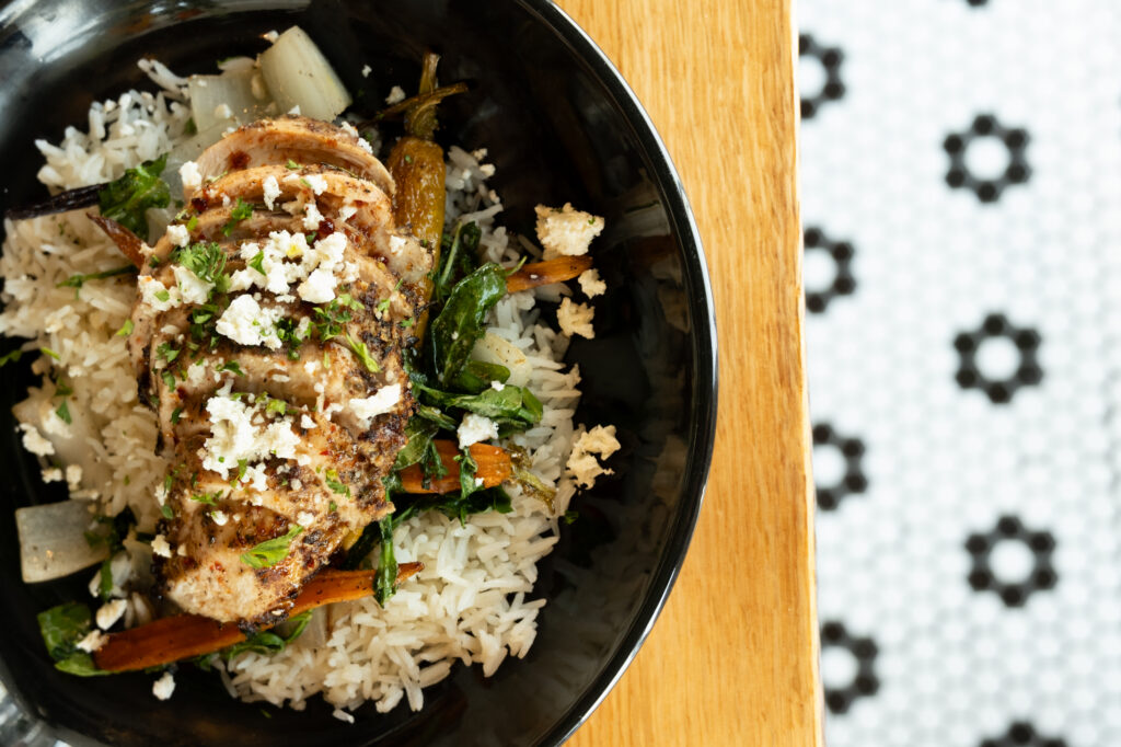 a black bowl filled with rice and meat