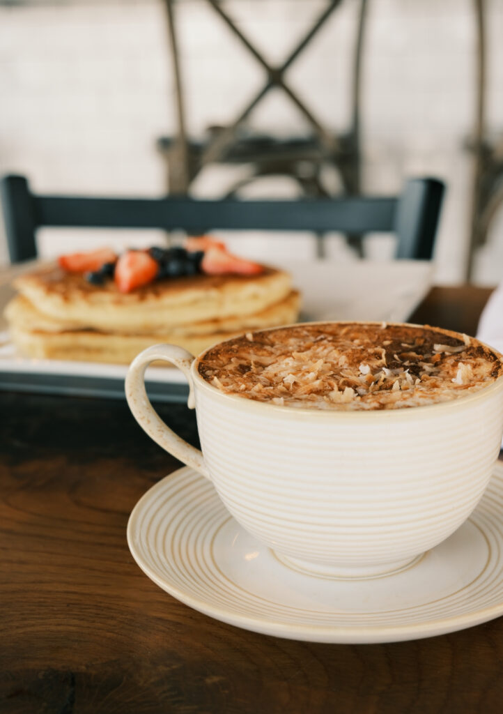 a cup of coffee sitting on top of a wooden table
