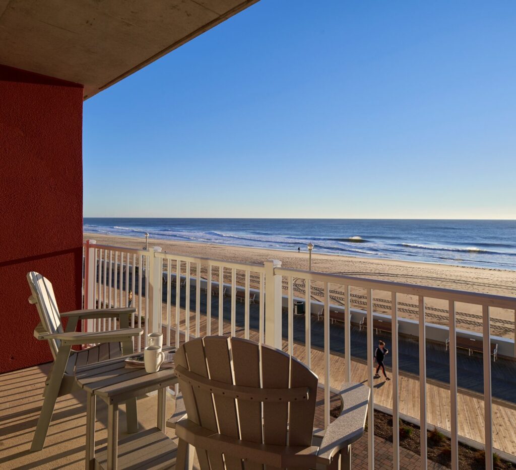 a balcony with chairs and a view of the beach