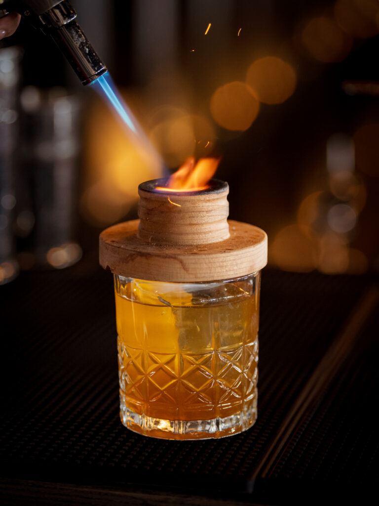 a person lighting a cigarette in a glass